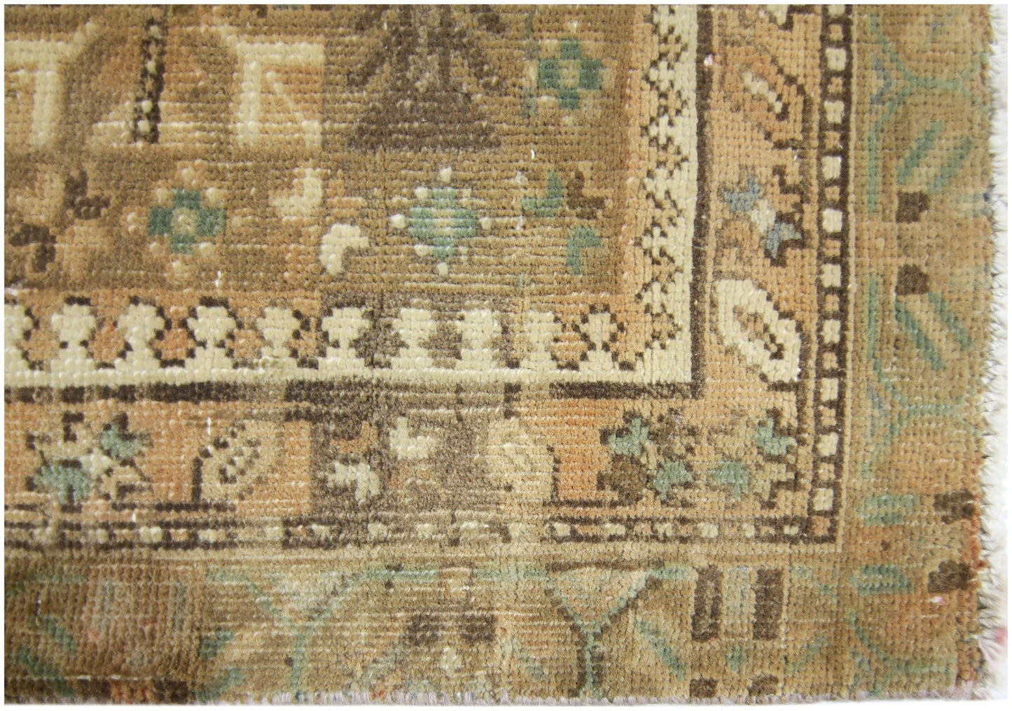 A close-up of a vintage Persian runner featuring intricate geometric patterns in earthy tones.