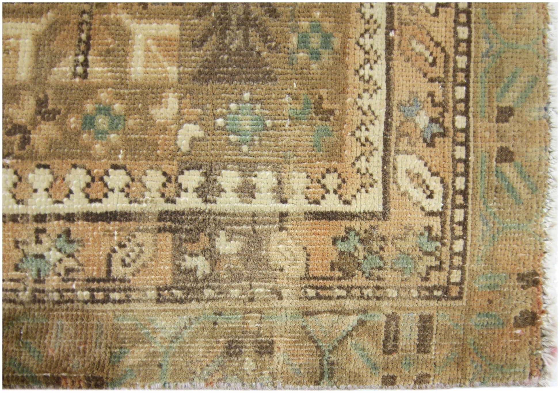 A close-up of a vintage Persian runner featuring intricate geometric patterns in earthy tones.