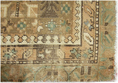 A close-up of a vintage Persian runner featuring intricate geometric patterns in earthy tones.