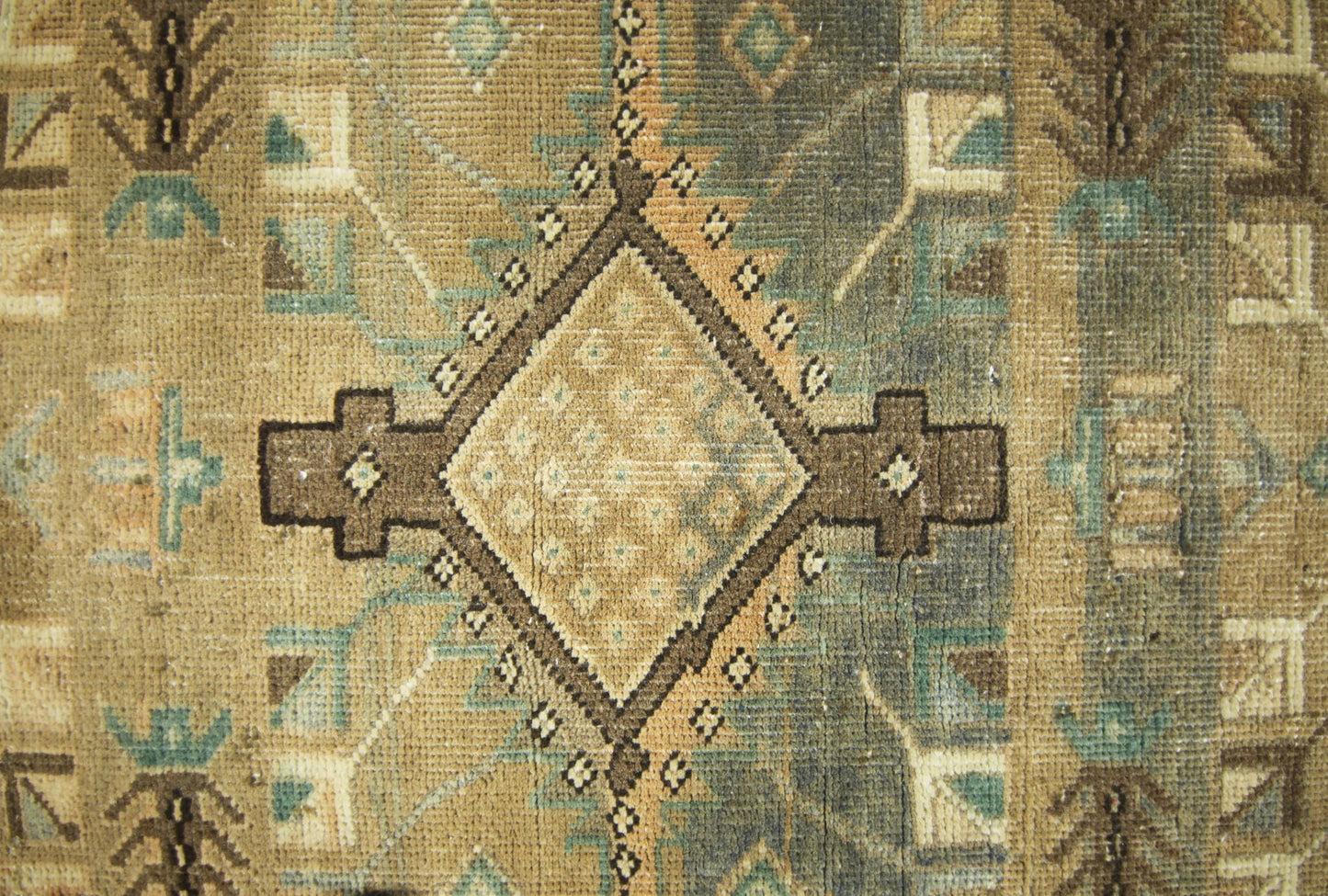 A vintage Persian runner featuring a geometric diamond pattern in muted brown and blue tones.