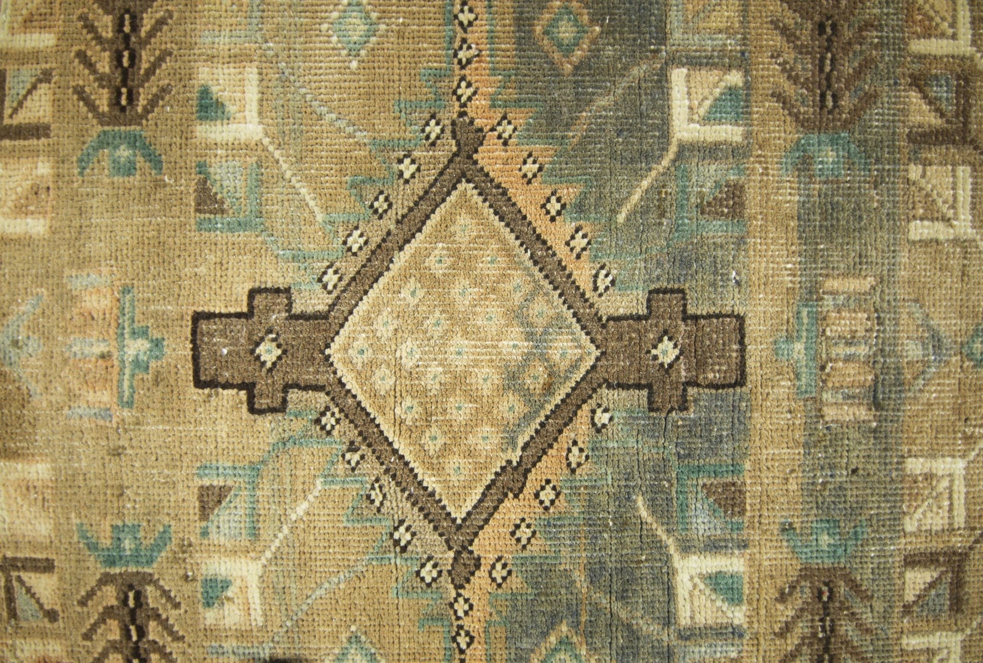 A vintage Persian runner featuring a geometric diamond pattern in muted brown and blue tones.