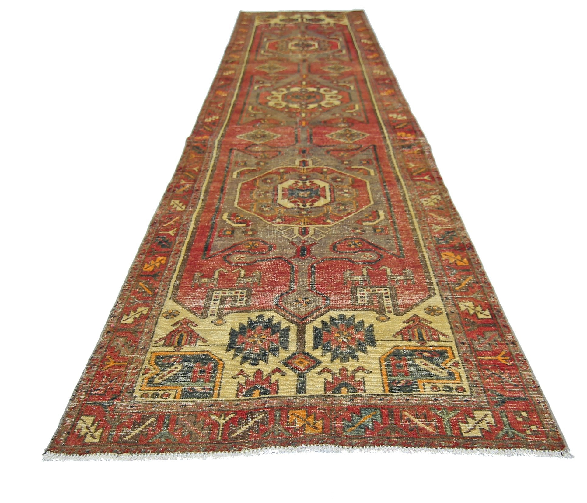 A vintage handmade Persian runner featuring a geometric pattern in red, beige, and blue tones.