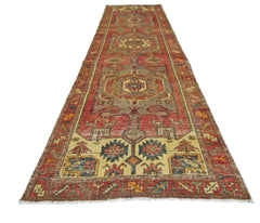 A vintage handmade Persian runner featuring a geometric pattern in red, beige, and blue tones.