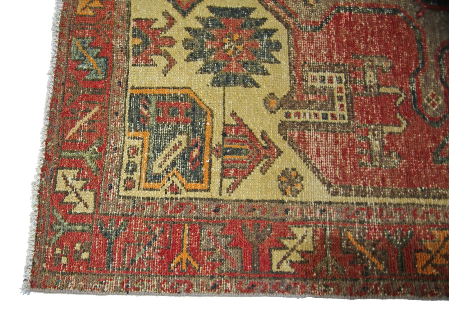 A vintage Persian runner featuring geometric tribal patterns in red, gold, and blue wool.