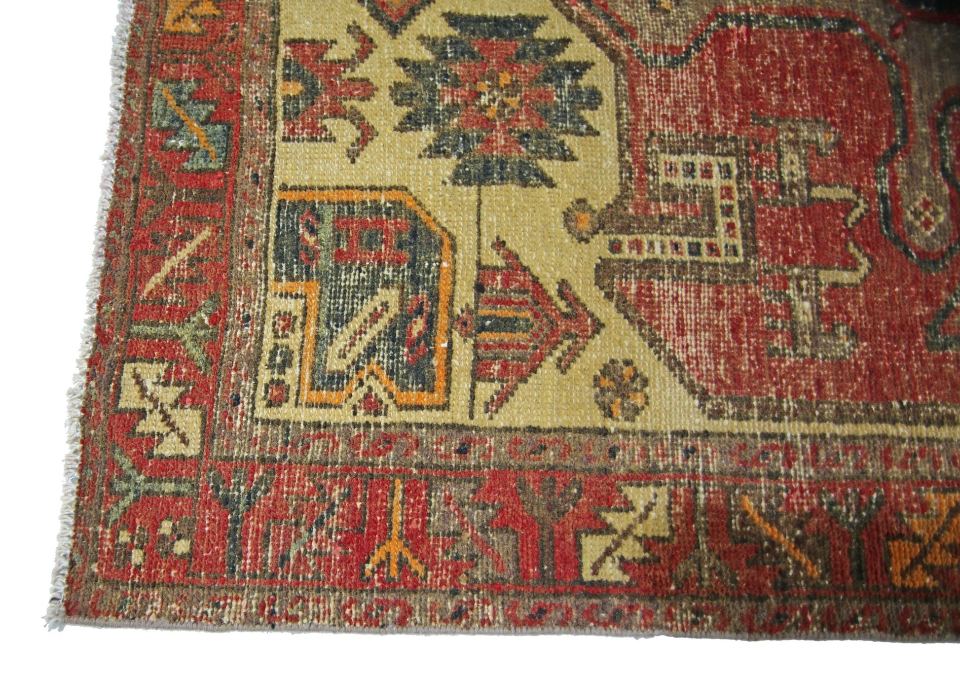 A vintage Persian runner featuring geometric tribal patterns in red, gold, and blue wool.