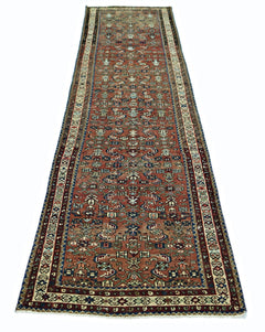 A vintage Persian runner rug featuring intricate geometric patterns in shades of red and blue.