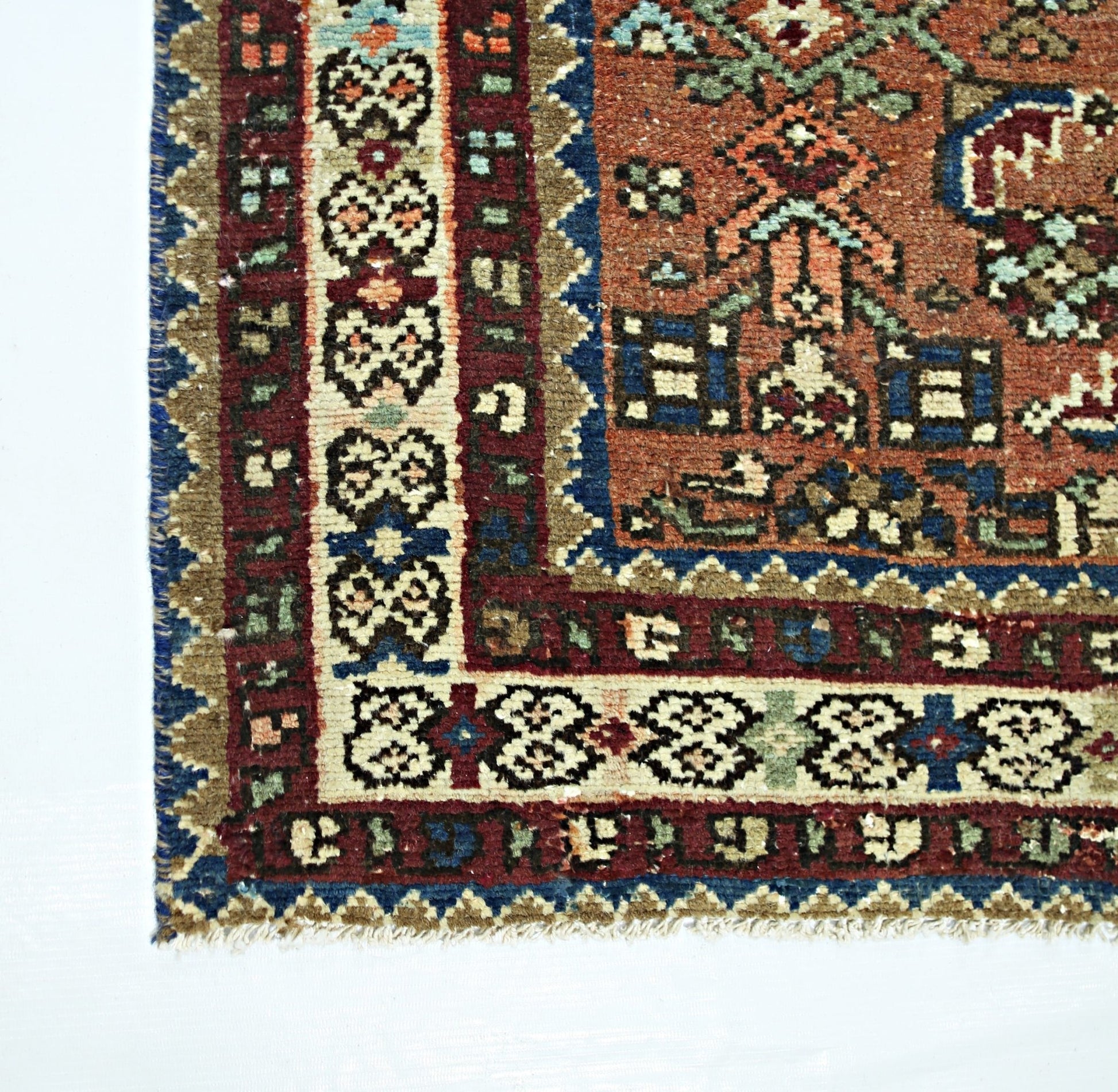 A vintage Persian runner featuring a geometric floral pattern in red, blue, and cream tones.