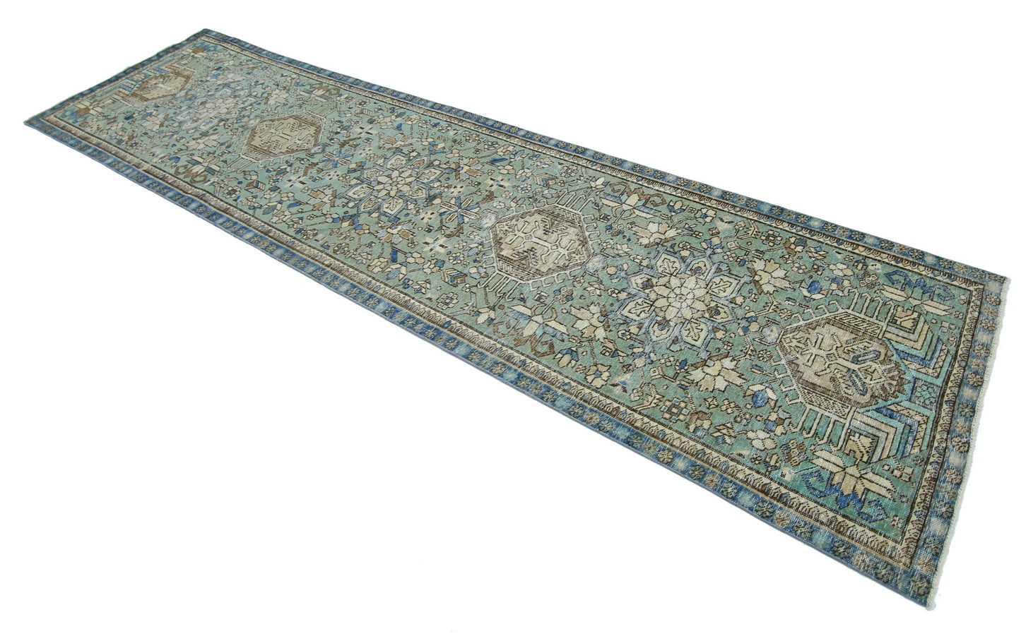 A long, handmade vintage Persian runner rug featuring intricate floral patterns in blue and beige.