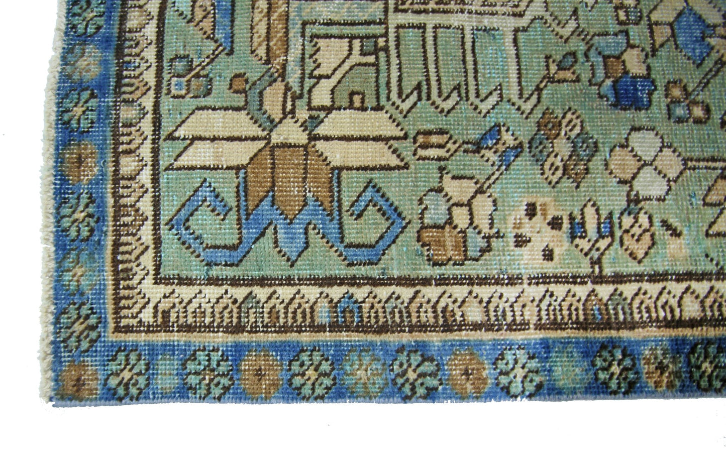 A vintage Persian runner featuring intricate floral patterns in shades of blue, green, and tan.