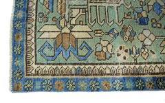 A vintage Persian runner featuring intricate floral patterns in shades of blue, green, and tan.