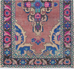 A vintage handmade Persian runner rug featuring a floral medallion pattern in pink and blue tones.