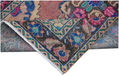 A folded vintage Persian runner featuring intricate floral patterns in blue, pink, and tan.