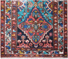 A vintage Persian runner featuring a central diamond medallion in red, blue, and teal wool.