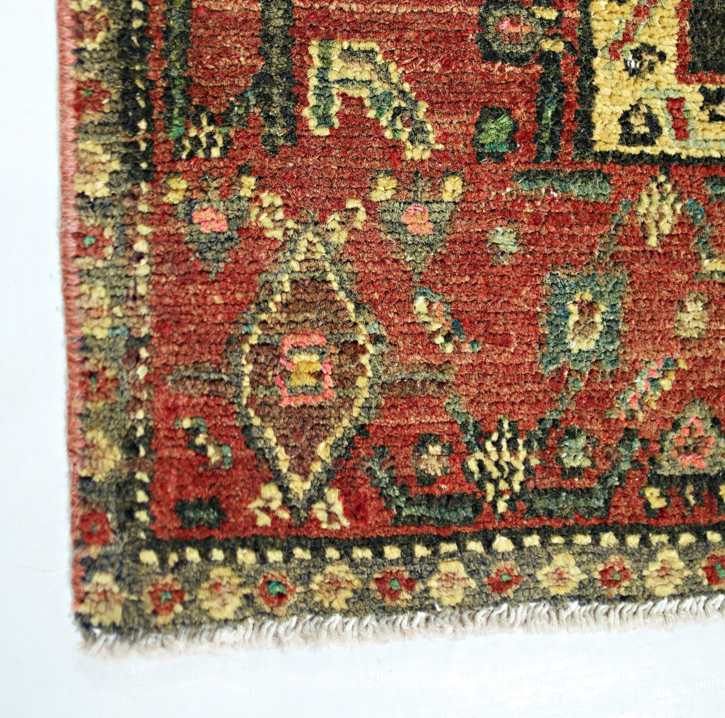 A vintage Persian Sanandaj rug featuring a red field with intricate floral and geometric patterns.