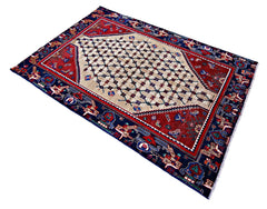 Vintage Persian Sanandaj rug featuring a cream diamond medallion, intricate red field, and detailed blue border.