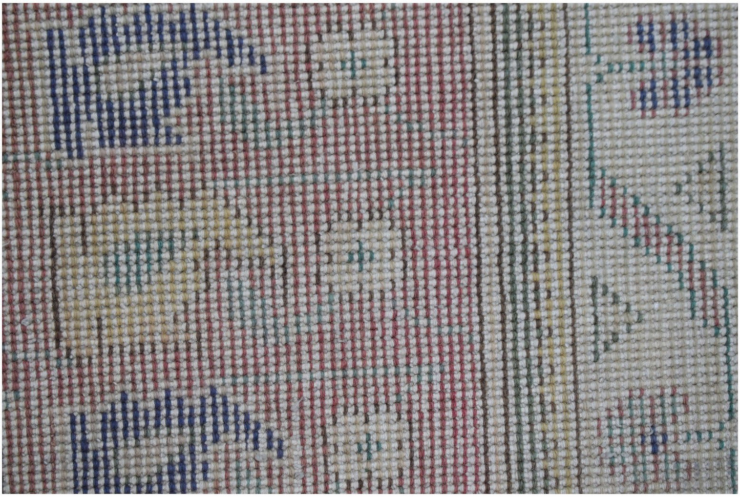 A close-up of a handwoven vintage Persian rug featuring geometric patterns in blue, red, and yellow.