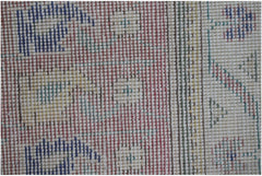 A close-up of a handwoven vintage Persian rug featuring geometric patterns in blue, red, and yellow.