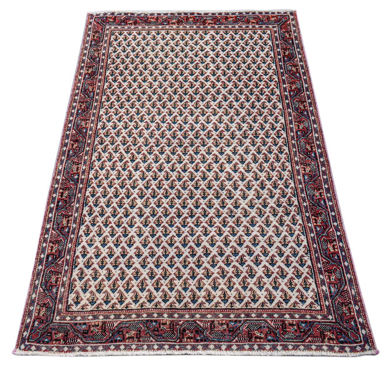A vintage handwoven Persian Saraband rug featuring a repeating boteh pattern on a cream field.
