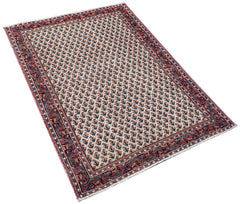 A vintage handwoven Persian Saraband rug featuring a repeating geometric pattern in red and blue.