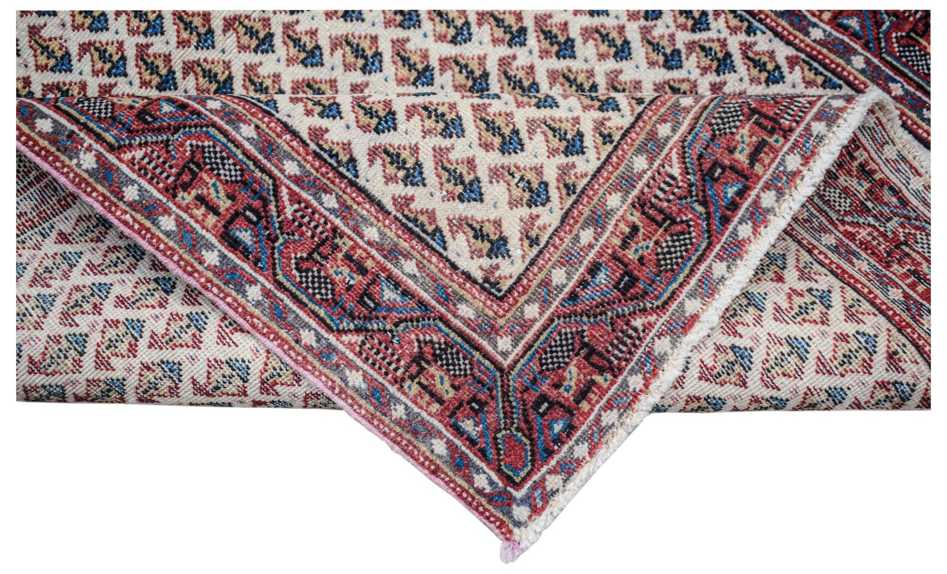 A vintage handwoven Persian Saraband rug featuring a repeating geometric pattern in red and blue.