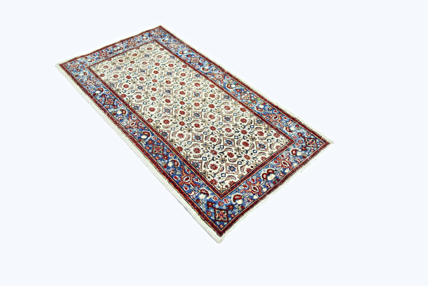 A vintage Persian Saraband rug featuring a repeating floral pattern in red and blue on a cream base.