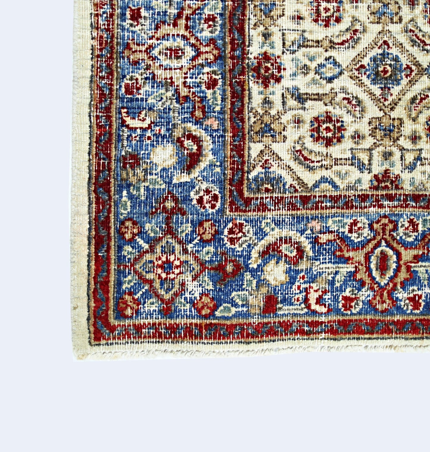 A vintage Persian Saraband rug featuring intricate floral patterns in red, blue, and cream tones.