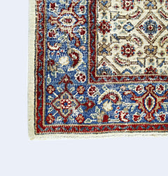 A vintage Persian Saraband rug featuring intricate floral patterns in red, blue, and cream tones.