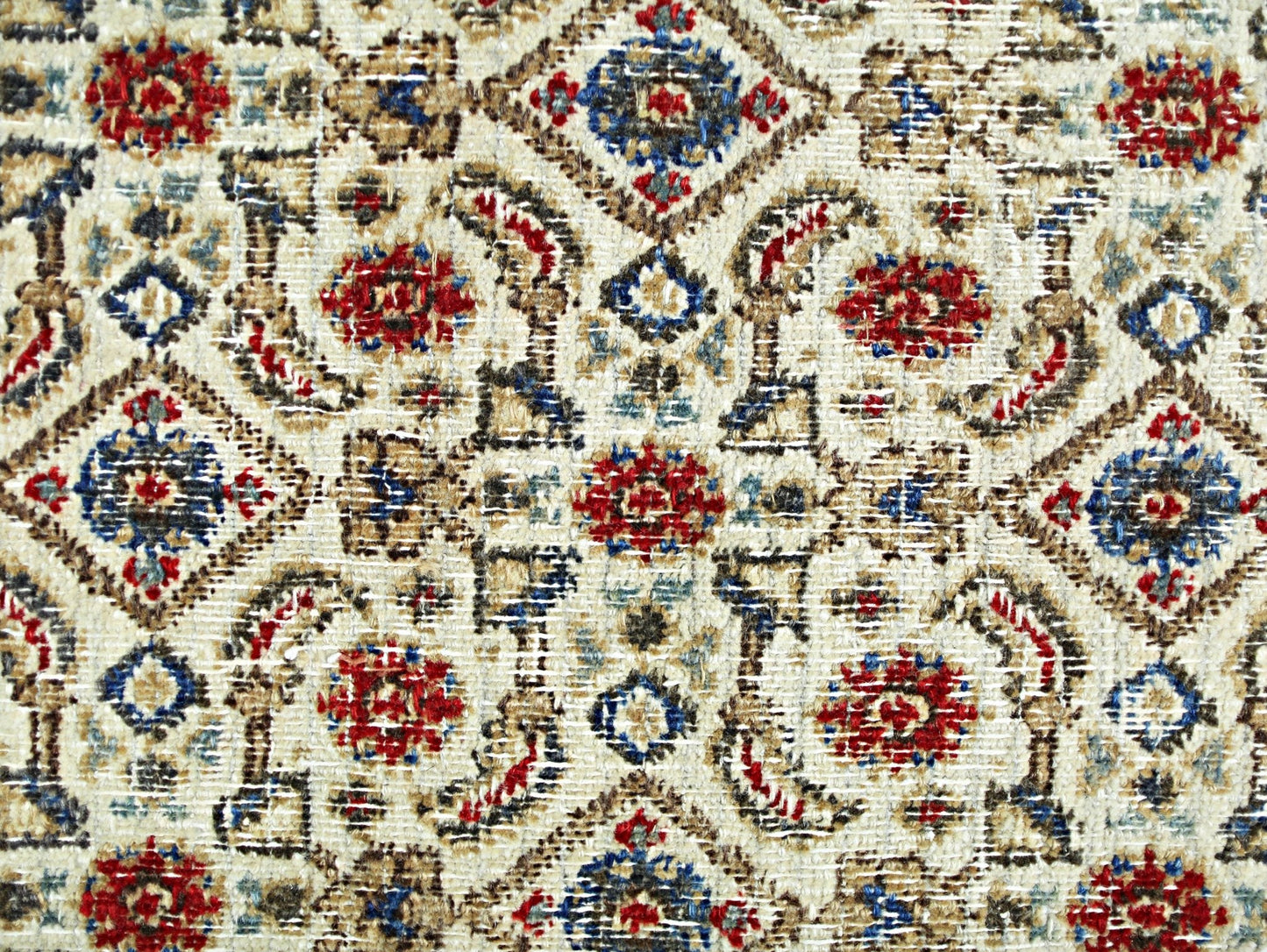 A vintage Persian Saraband rug featuring a repeating geometric pattern in red, blue, and tan.