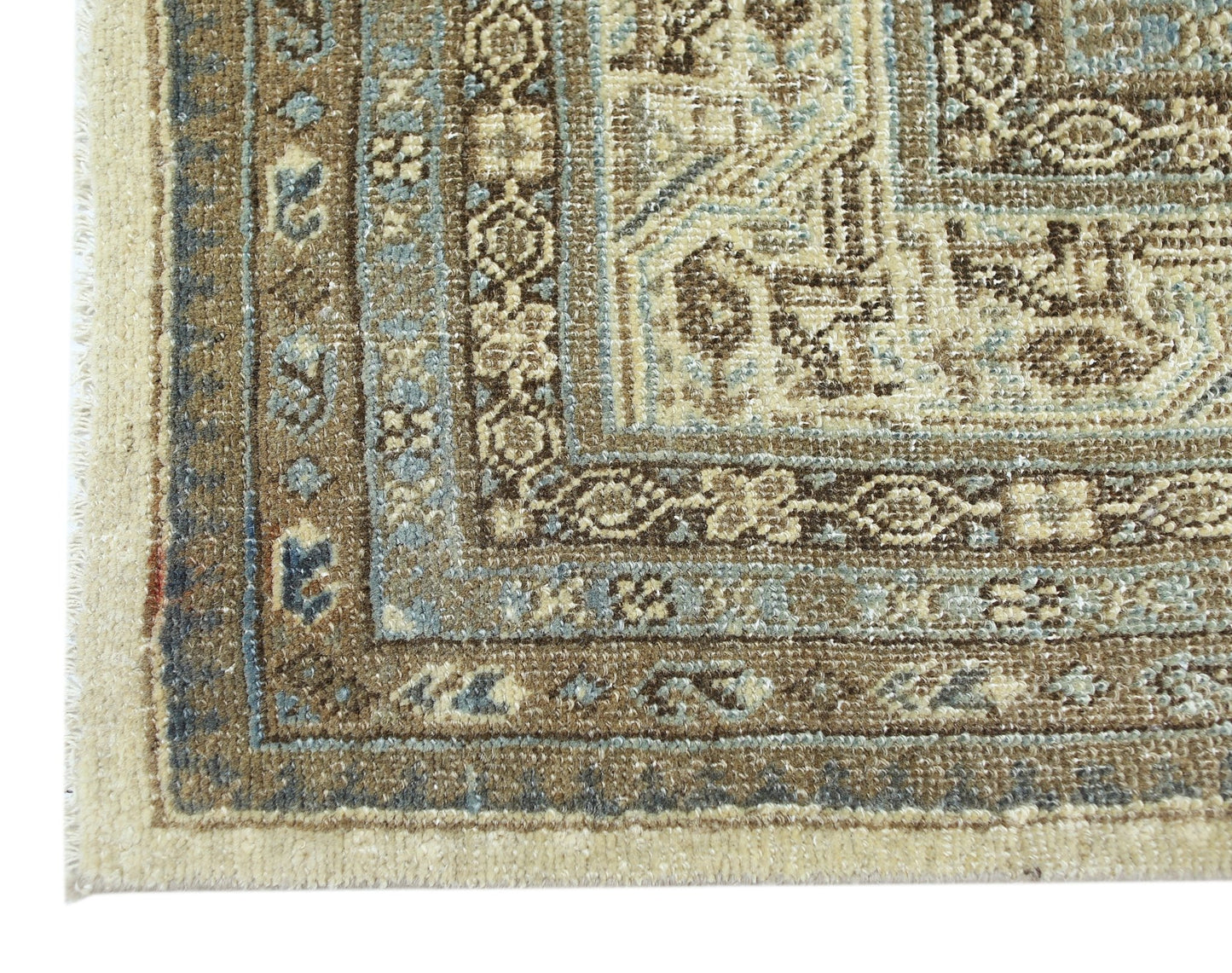 A corner view of a vintage Persian Saraband rug featuring intricate brown and blue floral patterns.