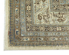 A corner view of a vintage Persian Saraband rug featuring intricate brown and blue floral patterns.