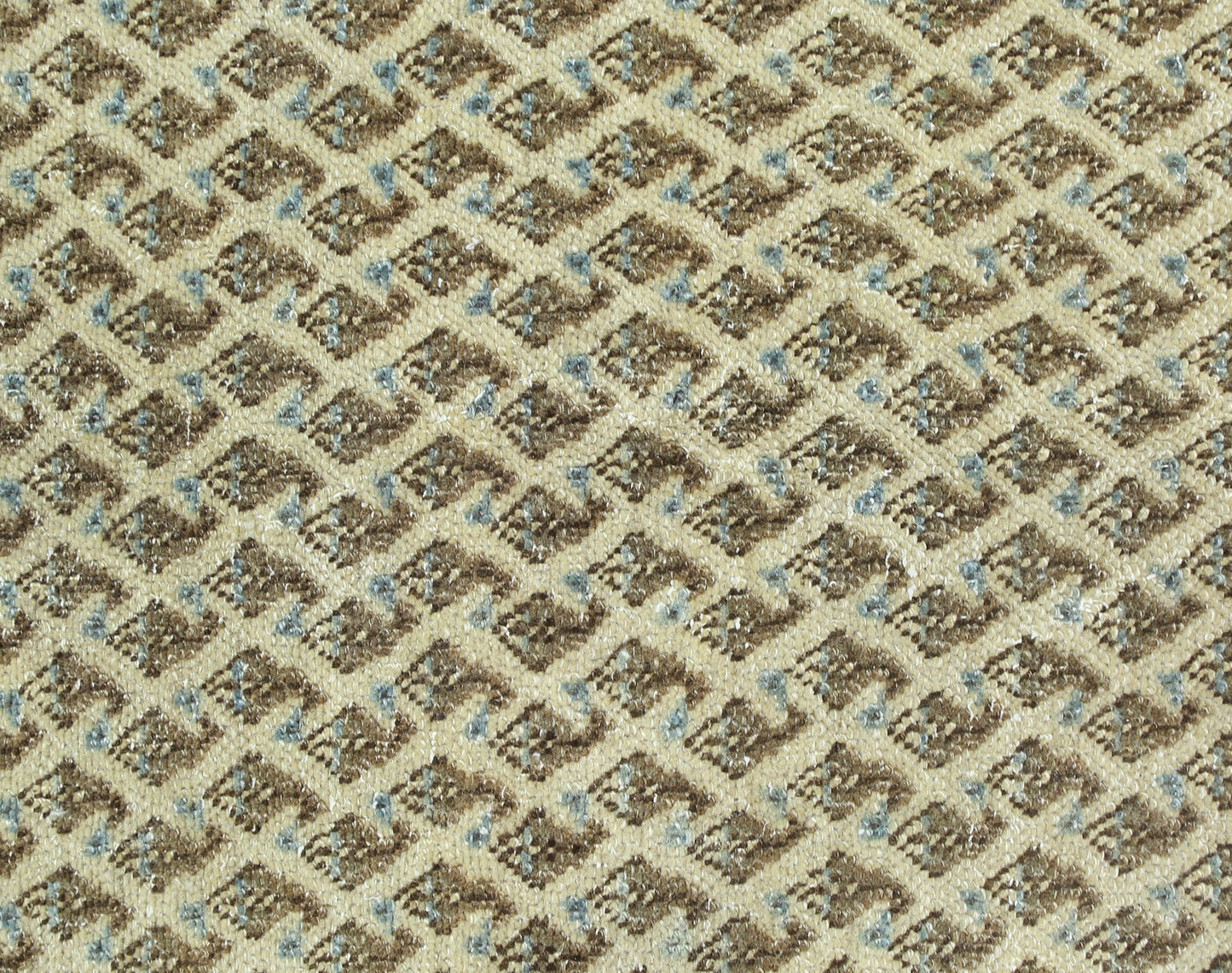 A close-up of a vintage Persian Saraband rug featuring a repeating geometric diamond pattern.