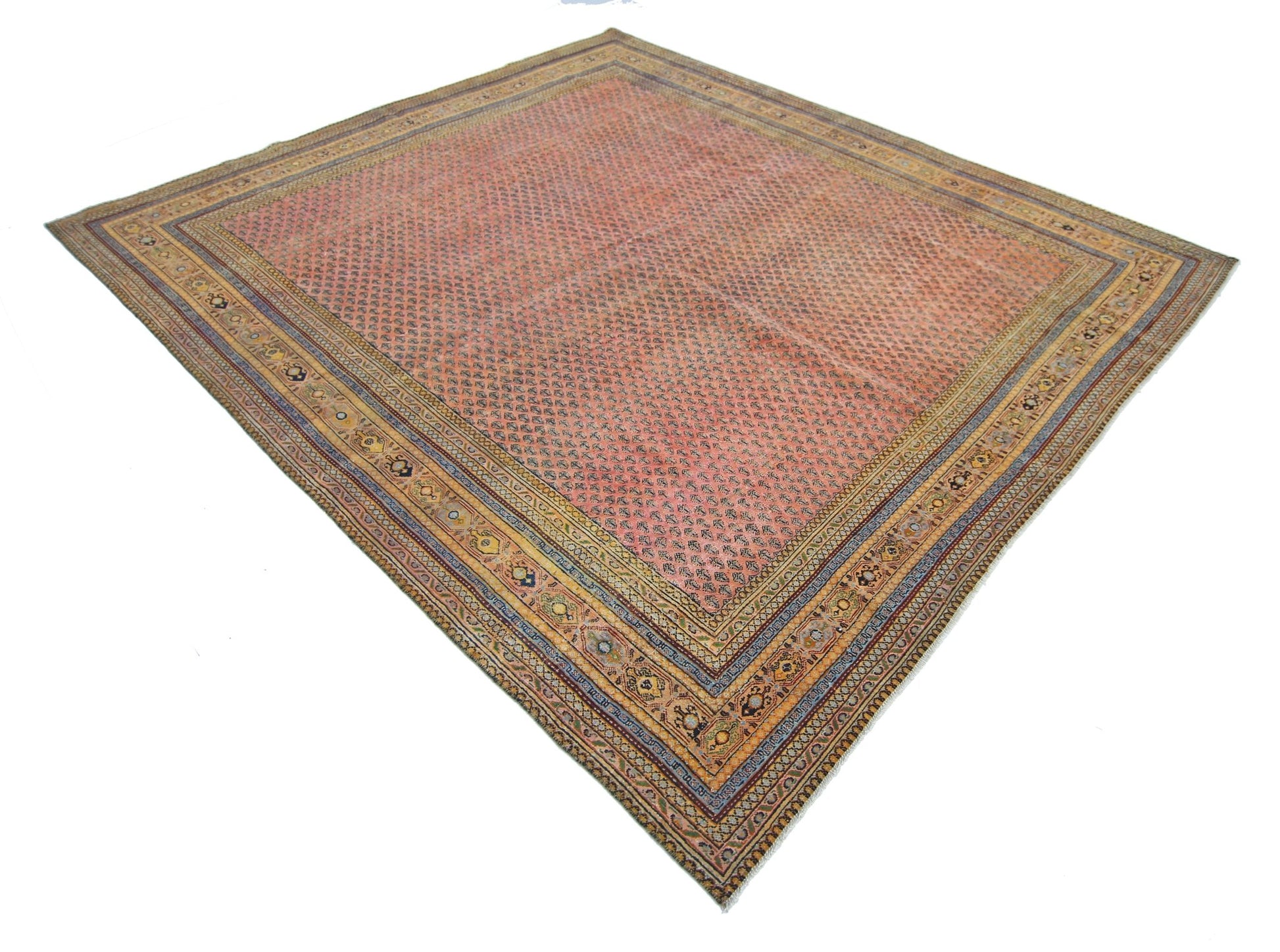 A vintage Persian Saraband rug featuring a repeating boteh pattern on a salmon pink field.