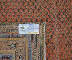 A vintage Persian Saraband rug featuring a repeating boteh pattern on a terracotta field.