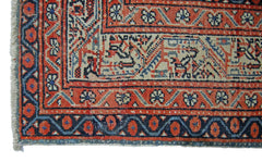 A vintage Persian Saraband rug featuring a traditional red and blue geometric border pattern.
