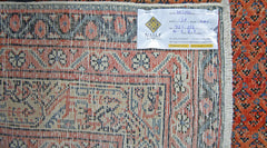 A vintage Persian Saraband rug featuring a detailed geometric pattern in red, blue, and cream.