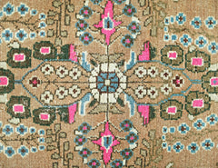 A vintage Persian Sarouk rug featuring a floral medallion pattern in pink, blue, and tan.