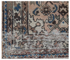 A close-up of a vintage Persian rug featuring intricate geometric patterns in muted earth tones.