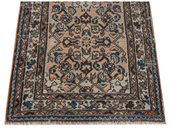 A handwoven vintage Persian rug featuring a geometric floral pattern in muted earth tones.