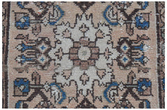 Mini vintage Persian rug with a central floral medallion and blue accents.
