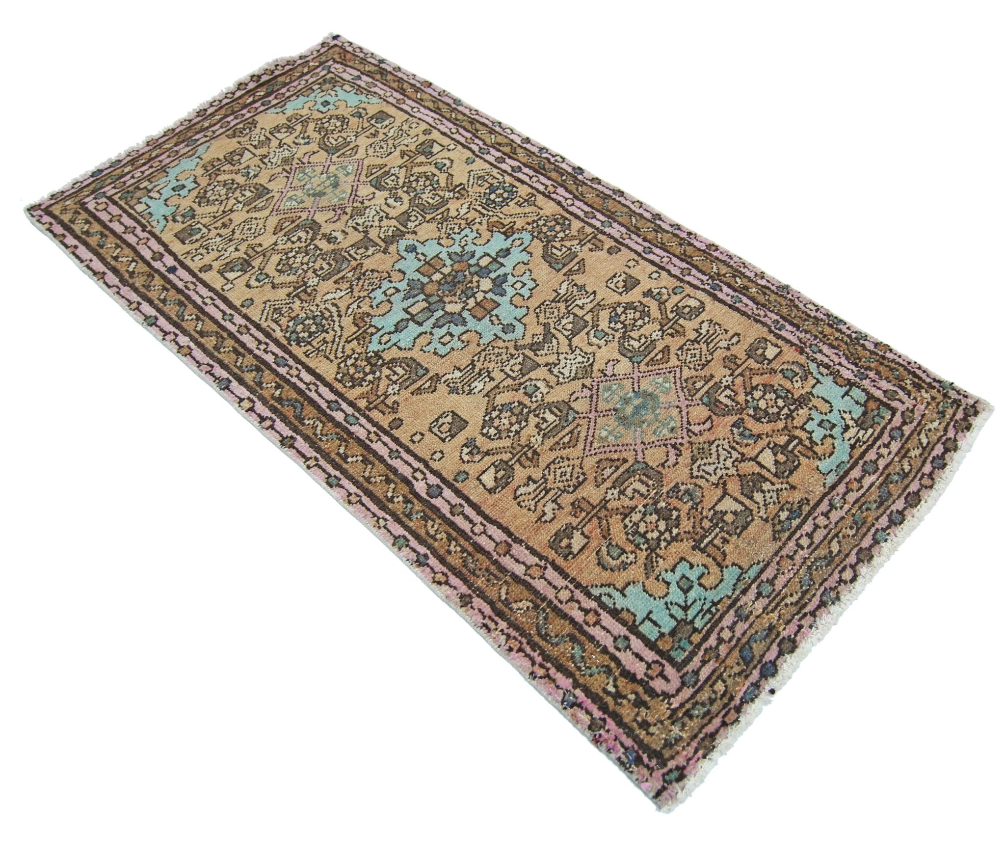 A rectangular vintage Persian rug featuring intricate geometric patterns in tan, blue, and pink.