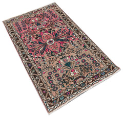 A vintage Persian Sarouk rug featuring a floral pattern in pink, brown, and teal tones.