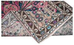 A vintage Persian Sarouk rug with a floral pattern in pink, blue, and brown tones.