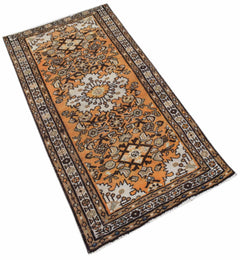 A handwoven vintage Persian rug featuring an orange field with intricate geometric patterns.