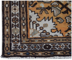 A corner view of a handwoven vintage Persian rug featuring geometric patterns in orange and brown.