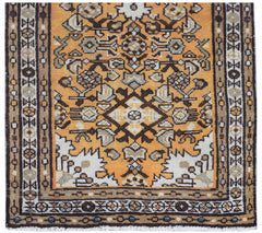 A handwoven vintage Persian rug featuring an intricate geometric pattern in orange and brown tones.