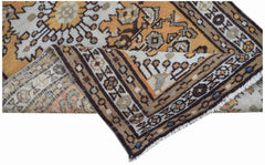A handwoven vintage Persian rug featuring geometric patterns in shades of orange, brown, and cream.