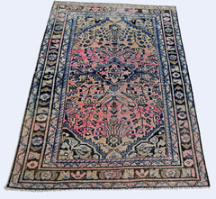 A vintage Persian rug featuring a central medallion with pink and blue floral patterns.