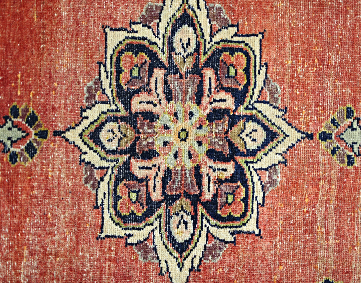 A vintage Persian rug featuring a detailed floral medallion pattern in shades of red, blue, and cream.