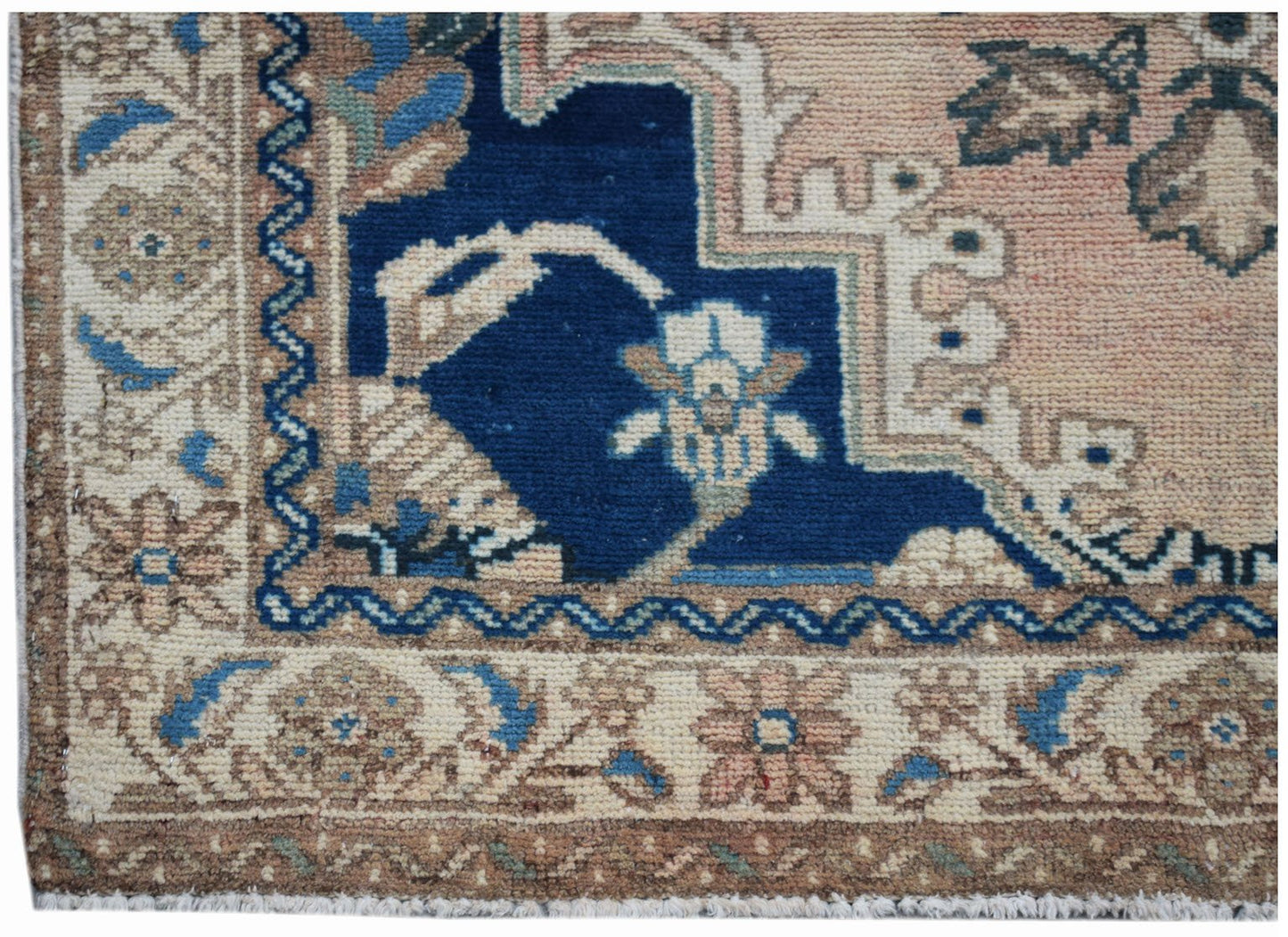 A vintage Persian Sarouk rug featuring a floral pattern in blue, pink, and beige tones.