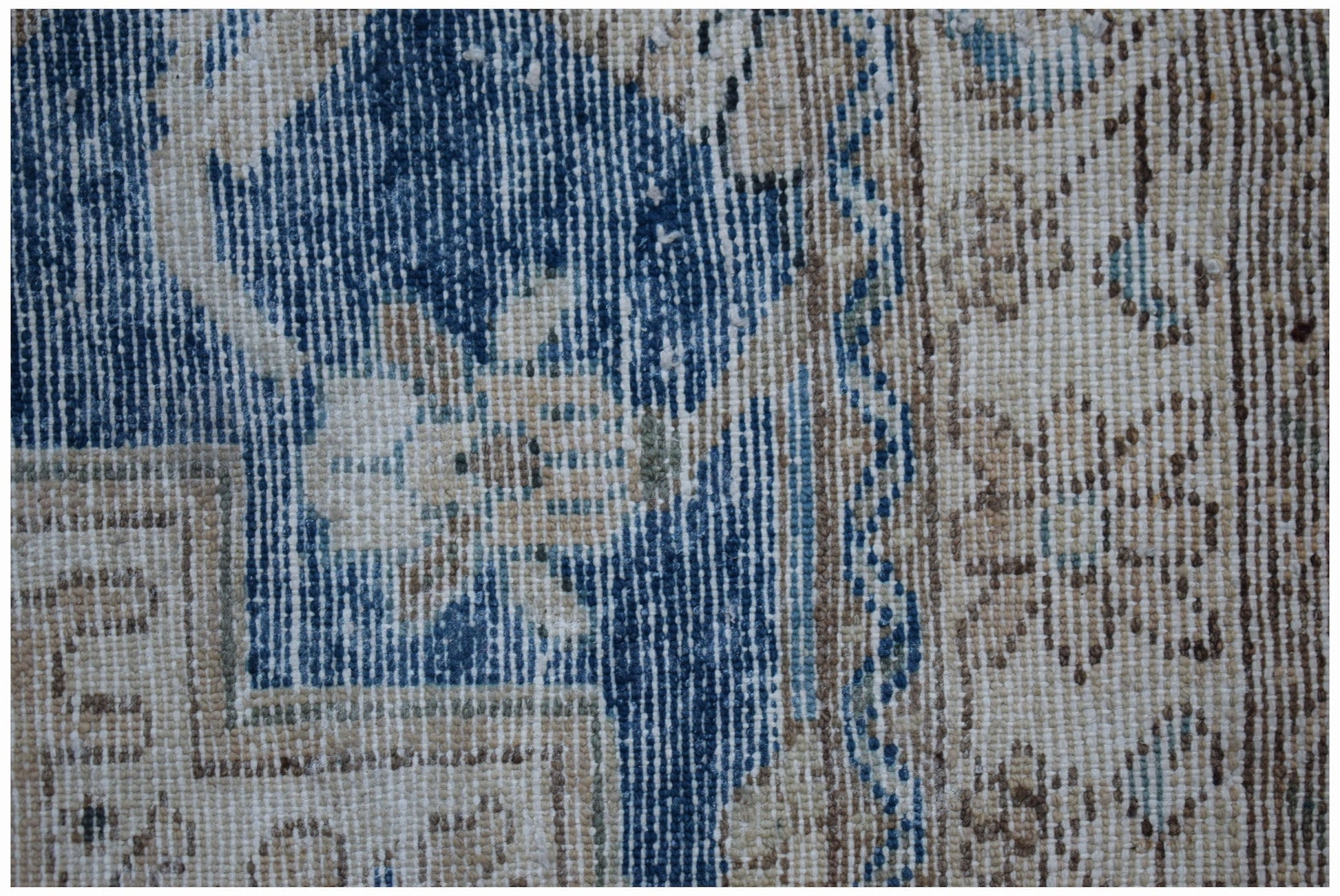 A close-up of a vintage Persian Sarouk rug featuring intricate floral patterns in blue and beige.